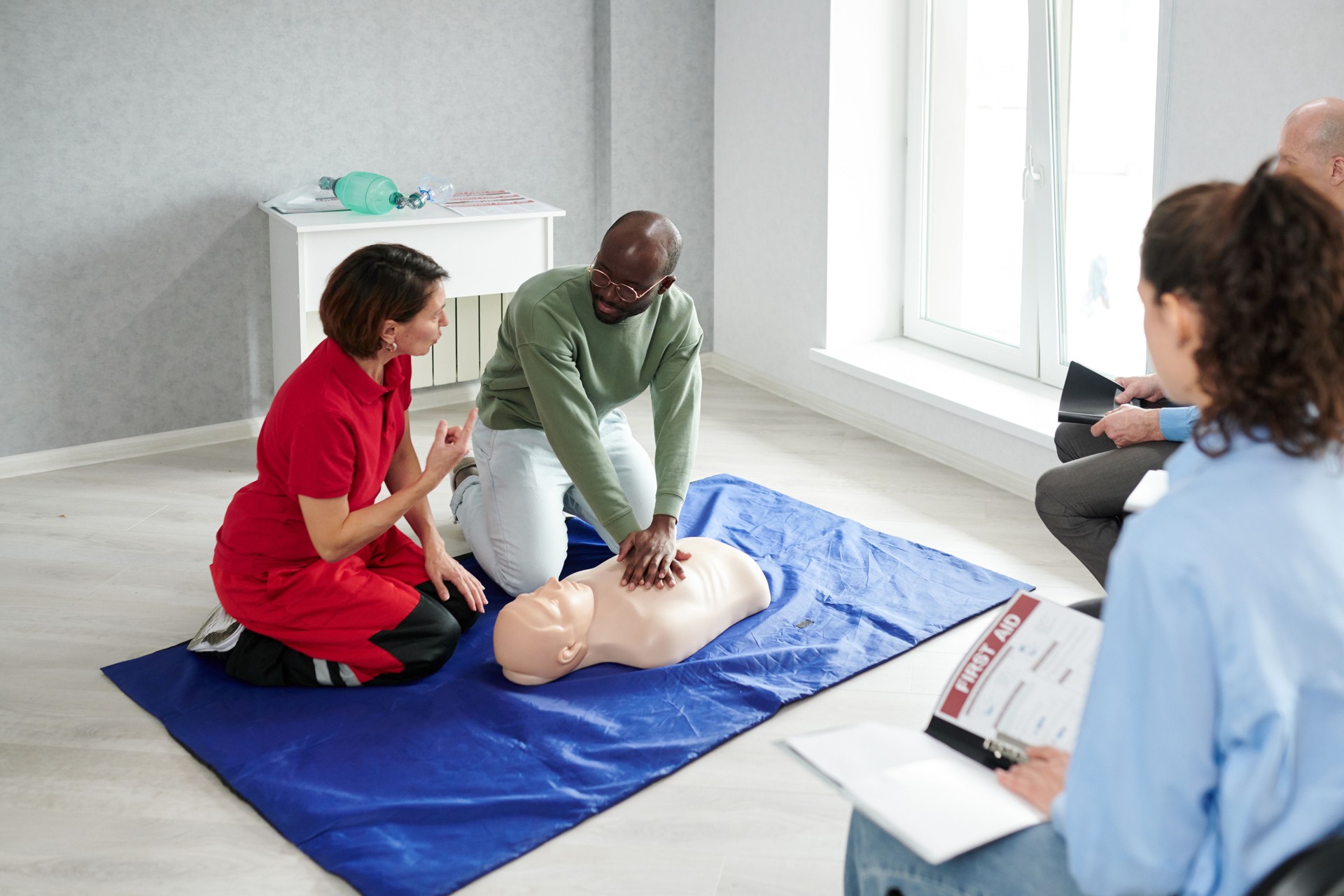 Female doctor showing chest compressions with dummy